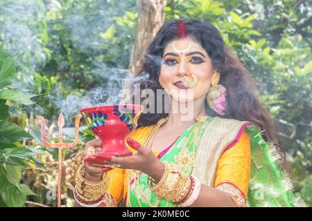 Married women performing dhunuchi dance on the occasion of Durga Agomoni as ritual ,Holy smoke covered entire area. Stock Photo