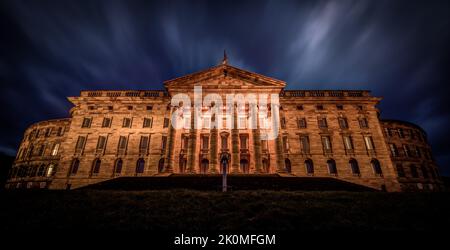 A dramatic view of the facade of the Neoclassical Wilhelmshohe castle at night in Kassel, Germany Stock Photo