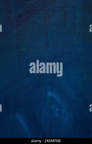 Close-up of a wall spray painted with dark blue. Abstract full frame textured grunge graffiti background with copy space. Stock Photo