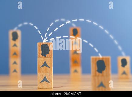 Close up photo of stacked wooden blocks with person silhouette linked to eachother as a symbol of consensus, teamwork and networking. Stock Photo