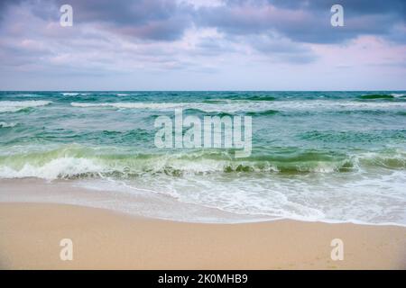 stormy weather in velvet season. seascape with clouds in evening light. waves crashing sandy beach. windy weather Stock Photo