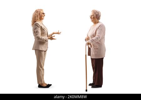 Full length profile shot of an elderly woman listening to a younger woman talking isolated on white background Stock Photo