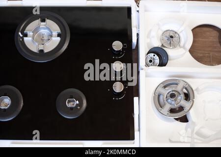 New gas three-burner built-in stove with electric ignition, disassembled in a box. Installation of cookers. Stock Photo