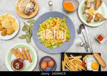 Recipes of dishes and tapas with croquettes of various flavors, salad with goat cheese, hamburger with fried egg, Venezuelan teques and arepa with shr Stock Photo