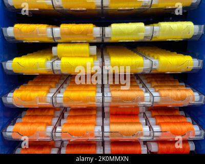 Sewing threads multi colored background. Colorful thread spools used in fabric and textile industry Stock Photo