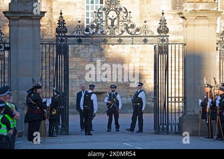 Holyrood, Edinburgh, Scotland, UK. 12th September 2022. Security for King Charles 111 at Scottish Parliament and  Holyrood Palace. Pictured: Armerd Polic officers stand at the gates of Holyrood Palace together with The Royal Company of Archers who were previously the official bodyguards of the Queen when she was in Scotland. Credit: Arch White/alamy live news. Stock Photo