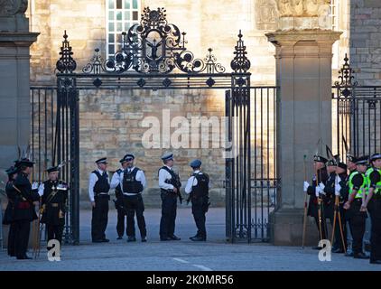 Holyrood, Edinburgh, Scotland, UK. 12th September 2022. Security for King Charles 111 at Scottish Parliament and  Holyrood Palace. Pictured: Armerd Polic officers stand at the gates of Holyrood Palace together with The Royal Company of Archers who were previously the official bodyguards of the Queen when she was in Scotland. Credit: Arch White/alamy live news. Stock Photo