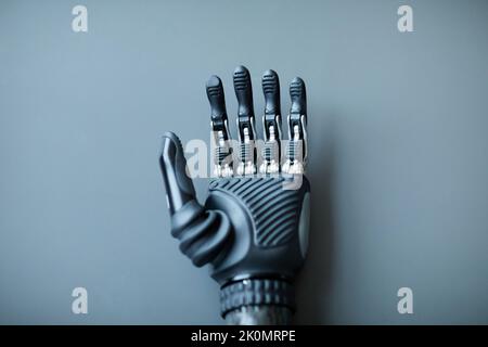 Close-up of prosthetic arm for people with disability isolated on blue background Stock Photo