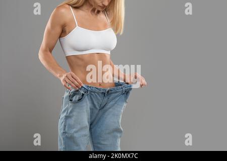 Dieting Concept. Closeup Shot Of Unrecognizable Fit Woman Wearing Oversize Jean Stock Photo