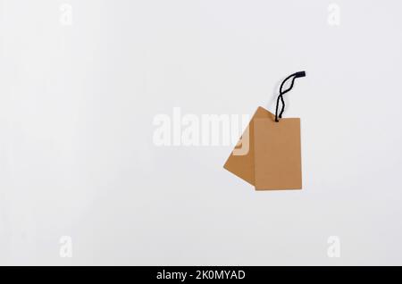 Empty brown cardboard tag with string on white background. Vintage paper textured tag. Mockup cardboard label. Price tag, gift tag, sale tag, address Stock Photo