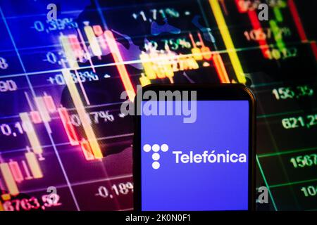 KONSKIE, POLAND - September 10, 2022: Smartphone displaying logo of Telefonica company on stock exchange diagram background Stock Photo