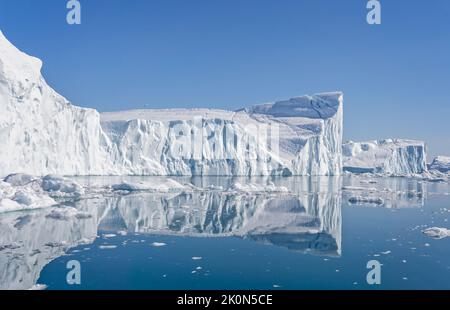 Towering great icebergs and their reflections in the Ilulissat Icefjord in Greenland Stock Photo