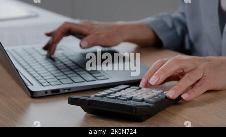 Close up female hands with manicure wrinkled unrecognizable senior woman cashier accountant calculate financial data pay online bills on computer Stock Photo