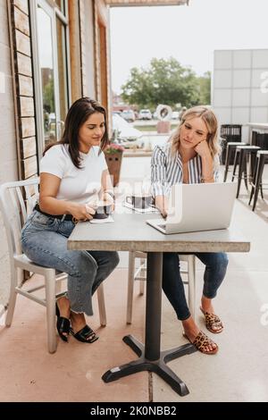 Two professional women work together outside a coffee shop Stock Photo