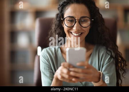 Closeup of happy brunette woman using smartphone Stock Photo