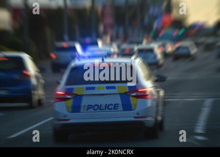 CHRISTCHURCH, NEW ZEALAND, AUGUST 30, 2022: A police car weaves through peak hour traffic on Moorhouse Avenue with its siren wailing and lights flashi Stock Photo