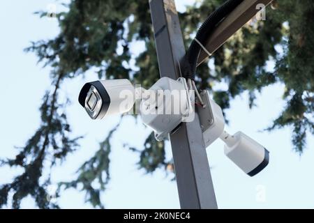 white security camera, blue sky in the background, technology and security systems. Stock Photo