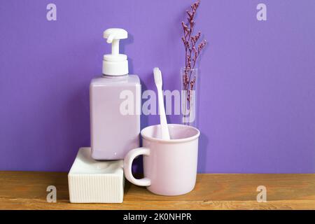 Bathroom accessories hygiene objects on wooden table. purple wall background Stock Photo