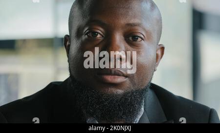 Portrait of sad african man male businessman teacher coach upset serious ethnic biracial bearded adult plus size thick guy with dark skin wears black Stock Photo