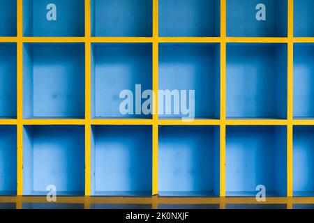 Front view of a blue wooden cabinet compartmentalize on cells with empty shelves. Stock Photo