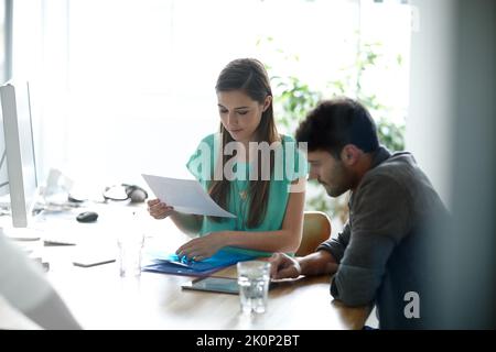 Focusing two minds on the task. young professionals working together in an office. Stock Photo