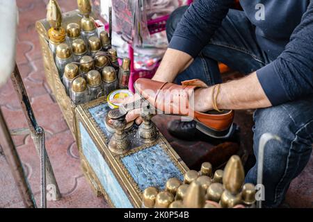 Ancient method of shoe cleaning. Man cleans shoes with help of shoe polish on street, close up. Stock Photo