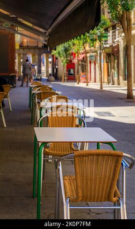 Empty tables set up outdoors at an al fresco street cafe near the Plaza Mayor in the center of Madrid, Spain Stock Photo