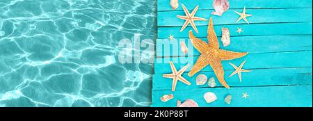Starfish, shells on wooden blue boards of pier with water of sea. Vacation, travel, beach. Banner. Copy space Stock Photo