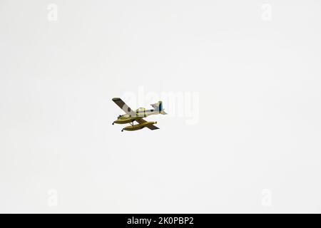 Firefighting seaplane flying through a clear sky before pouring water on the fire. Aerial firefighting. Stock Photo