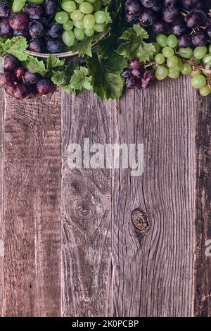 Wooden Background with Colorful Grapes and Leaves. High quality photo Stock Photo