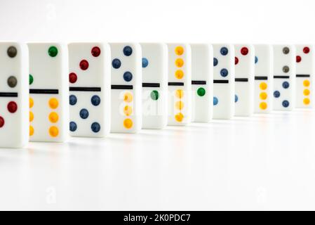 Dominoes. Dominos pieces with colorful dots in row on white background. Stock Photo