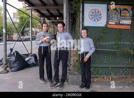 3 orthodox Jewish brothers wait for their school bus on Lee Avenue in Williamsburg, Brooklyn, New York City. Stock Photo