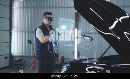 Car service manager conducts car diagnostics using holographic hud interfaces and vr headset. The specialist studies the serviceability of the engine and other parts of the car in 3D cyber space. Stock Photo