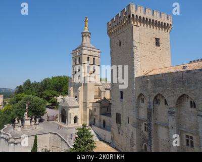 Avignon Cathedral with a gilded statue of Virgin Mary on top next to Famous Papal palace in France. Stock Photo