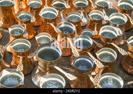 Many golden copper pots or kettles, used for making Turkish coffee. Stock Photo