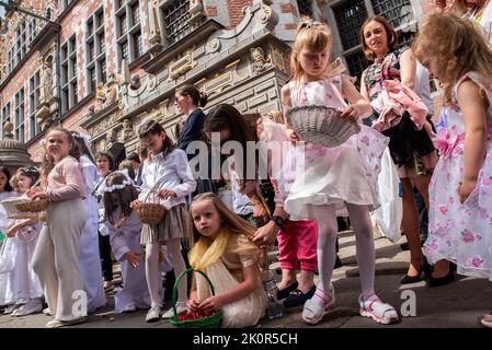 Kids seen dressed in white dresses during the procession. Corpus Christi - liturgical celebration in the Catholic Church in honor of Jesus Christ in the Blessed Sacrament. A procession of believers passed through the streets of Gda?sk. Stock Photo