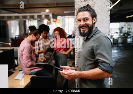 Diverse group of professionals meeting in office. IT programmers use computer, talk strategy Stock Photo