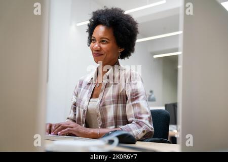 Young business woman working on desktop computer at modern startup office Stock Photo