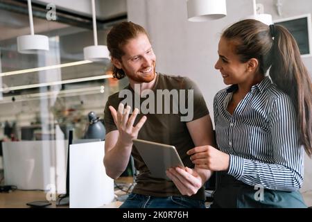 Smiling diverse colleagues gather in boardroom brainstorm discuss financial statistics together Stock Photo