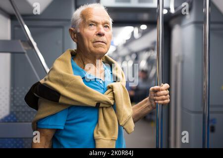 Elderly man in subway train Stock Photo