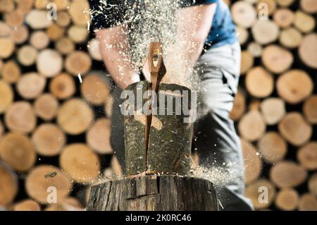 Hand and axe in firewood, chopping wood for fire heat Stock Photo