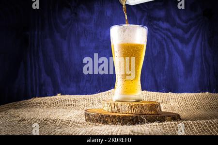 Beer can serving in a crystal glass on a blue wooden textured background Stock Photo