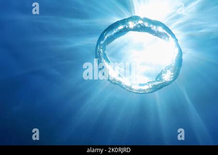 Underwater Bubble Ring Ascends towards the Sun Stock Photo