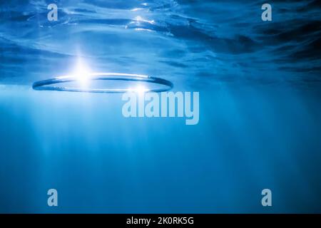 Underwater Bubble Ring Ascends towards the Sun Stock Photo