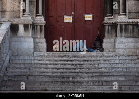 Man laying on the steps of the Sacred heart Basilica in Paris, France Stock Photo