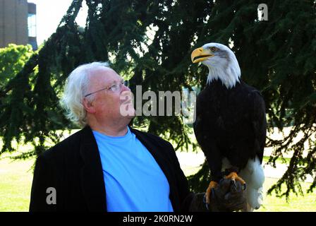 TV, stage & theatre & Doctor Who actor Colin Baker, holding a bald eagle (Haliaeetus leucocephalus) on a jess, during a falconry event at Gen Con 2007 Stock Photo