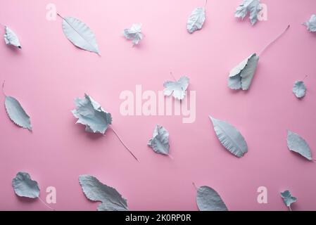 autumn pastel background blue leaves in paint on a pink background. Stock Photo