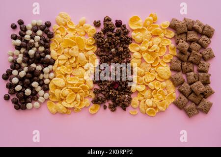 top view of assorted breakfast cereals, corn flakes and crispy granola isolated on pink,stock image Stock Photo