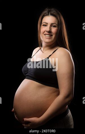 Premium Photo | Pregnant young woman with a big belly in a black dress poses  with a glass of carrot juice