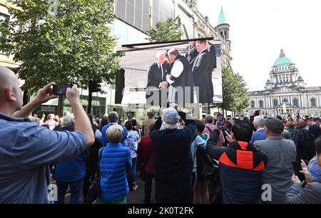 Crowds gather at screens outside Belfast City Hall to watch a Service of Reflection for Queen Elizabeth II at nearby St Anne's Cathedral. attended by King Charles III and the Queen Consort during their visit to Northern Ireland. Picture date: Tuesday September 13, 2022. Stock Photo